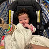 aisle, arm, baby, blanket, car_seat, child, clothing, cute, fabric, hair, happy, indoor, infant, person, seat, shopping_cart, smiling, store, tattoo, toy