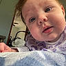 Noelle Ryann is registered to the contest to win money with this photo: baby, blanket, blue_eyes, child, chubby_cheeks, close_up, cozy, curious, cute, face, hand, heart_pattern, indoor, infant, person, portrait, purple_clothing, room, soft_light, toddler