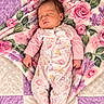 baby, newborn, sleeping, infant, portrait, floral_blanket, quilt, pink, purple, cream, pajamas, onesie, indoors, lying_down, peaceful, closed_eyes, face, hands, feet, cozy