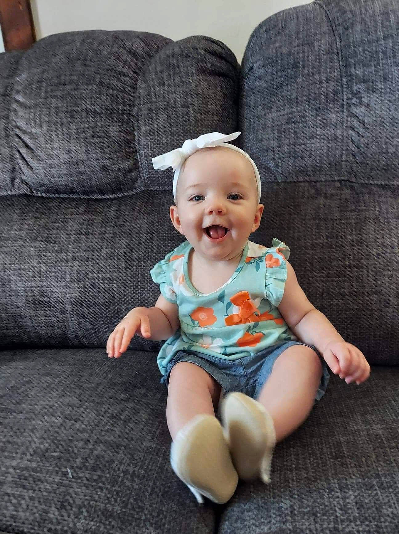 Kaylynn joined the competition — help win amazing prizes! baby, baby_toddler_clothing, comfort, couch, eye, face, foot, grey, happy, human_leg, knee, leg, pattern, person, skin, sleeve, smile, t_shirt, textile, thigh