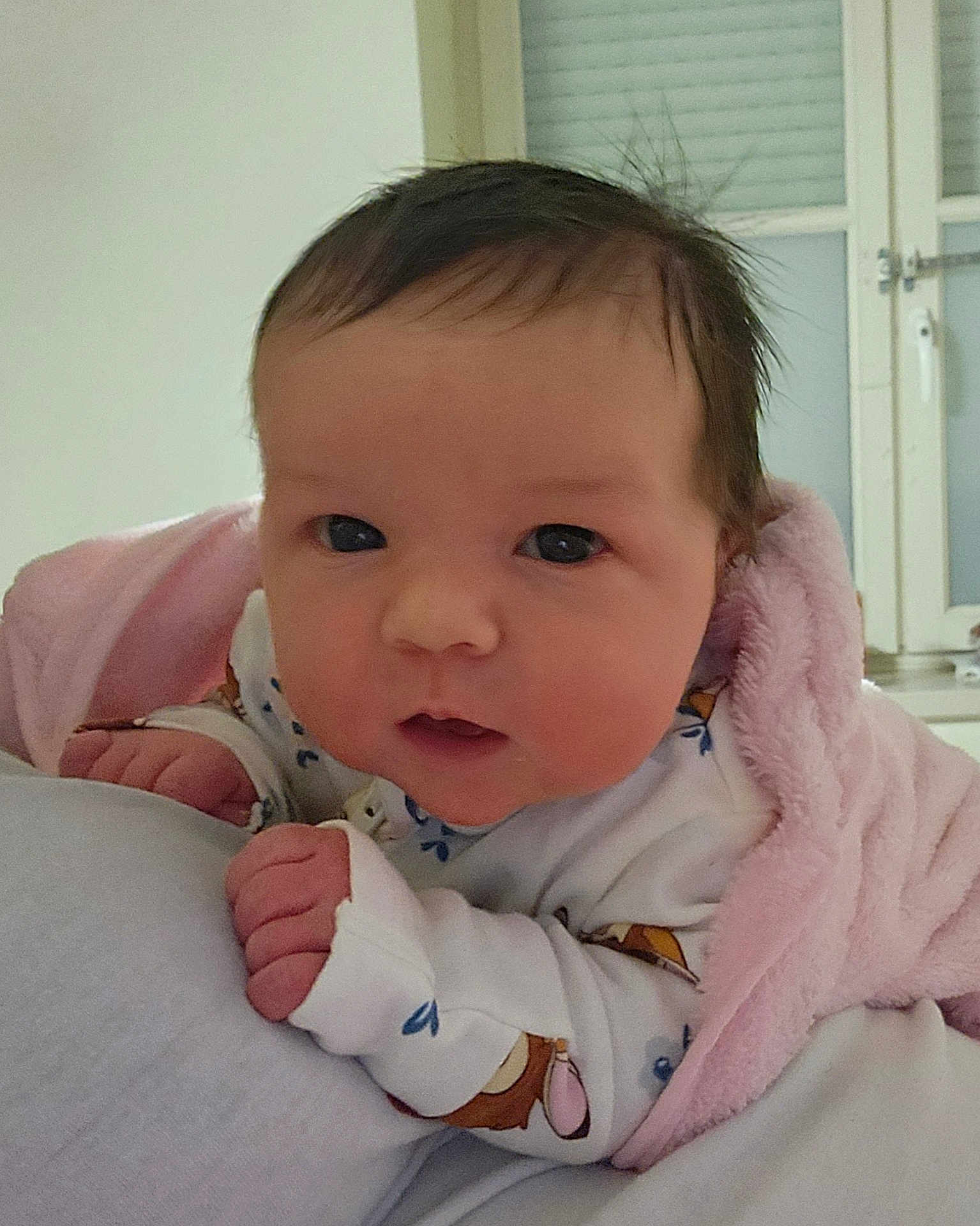 Aria a rejoint le concours — aidez-le/la à gagner de superbes lots ! baby, infant, face, eyes, blanket, pink_blanket, white_clothing, indoor, curly_hair, newborn, closeup, portrait, resting, cute, soft_texture, child, human, person, skin, cozy