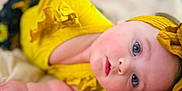 Ezlynn joined the competition — help win amazing prizes! baby, child, face, blue_eyes, yellow_clothing, headband, portrait, skin, infant, cute, soft_light, close_up, lying_down, bed, fabric, expression, curious, person, indoor, newborn
