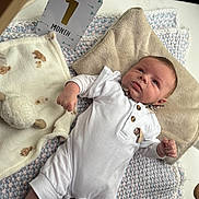 élyo a rejoint le concours — aidez-le/la à gagner de superbes lots ! baby, infant, one_month, white_onesie, blanket, pillow, soft_toys, floor, indoor, cute, newborn, child, lying_down, portrait, young_baby, cozy, warm, resting, curious, small