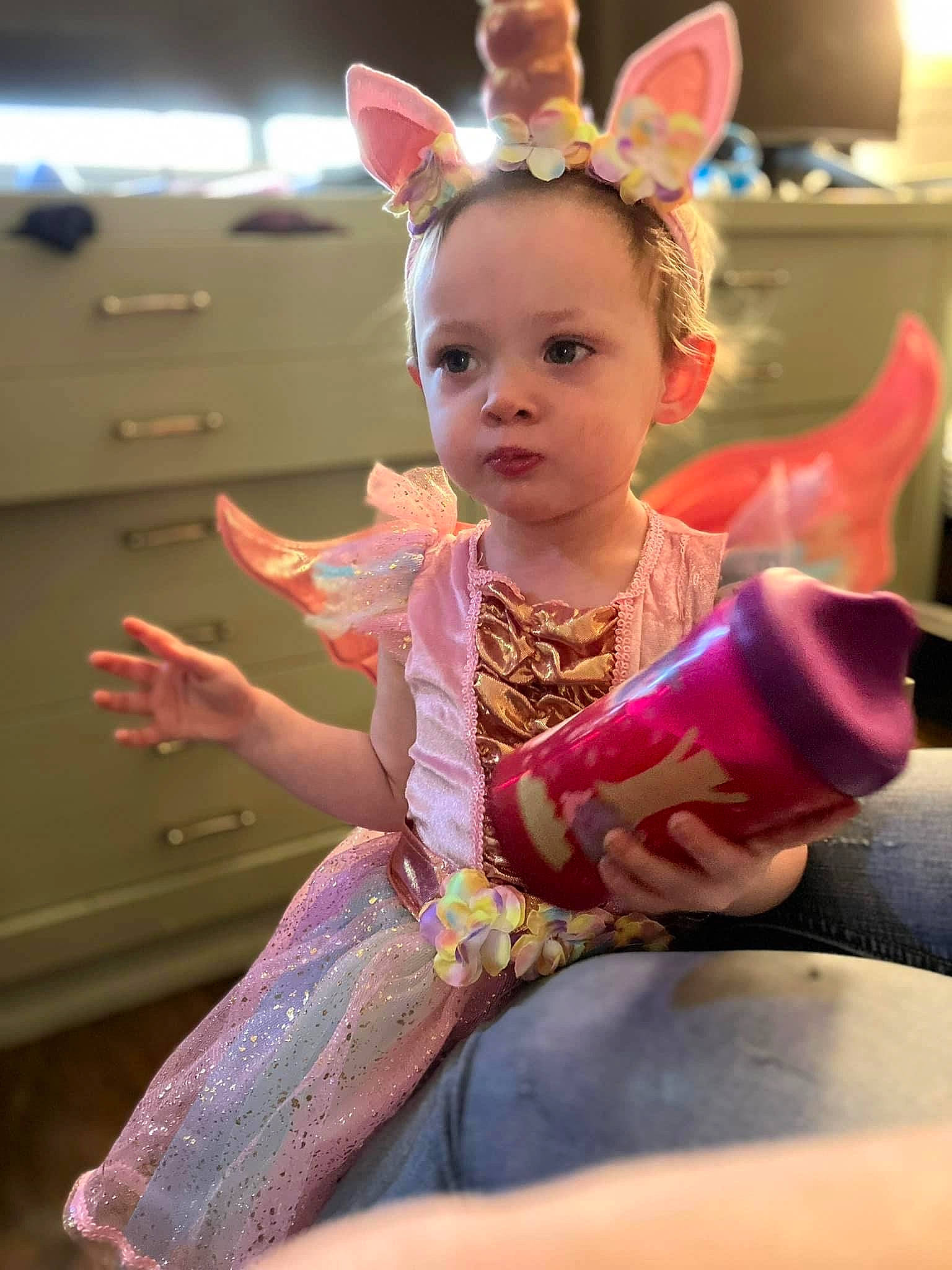 Remmi is registered to the contest to win money with this photo: baby, child, costume, ear, event, fashion_design, fun, happy, head, human_body, leisure, magenta, peach, person, pink, room, sitting, skin, toddler, tradition