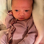 Evangeline is registered to the contest to win money with this photo: baby, infant, newborn, blanket, onesie, sleepwear, soft, cozy, cute, face, head, person, skin, hand, clothing, lying_down, indoors, portrait, young, resting