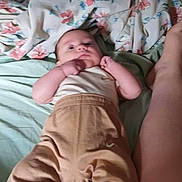 Dustin Lee Willis is registered to the contest to win money with this photo: baby, infant, bed, blanket, floral_pattern, person, clothing, pants, top, foot, leg, indoor, sleepwear, lying_down, skin, human, cute, child, cozy, resting