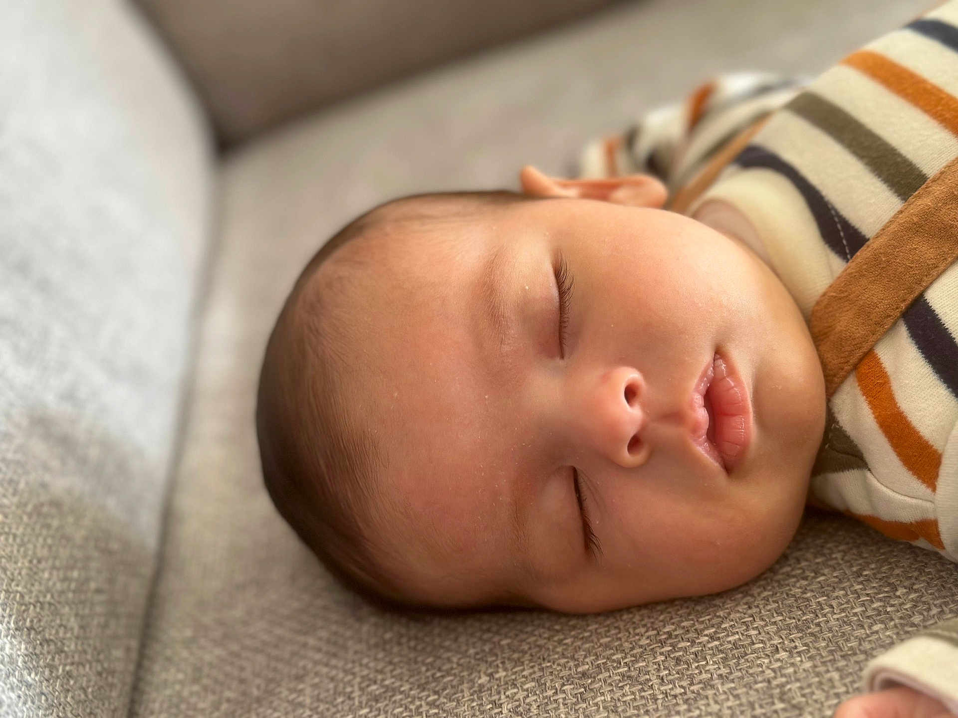 Matéo participe au concours pour gagner de l'argent avec cette photo : baby, sleeping, face, infant, couch, striped_clothing, closeup, peaceful, soft_light, skin, head, eyelashes, mouth, nose, texture, fabric, hand, cozy, rest, portrait