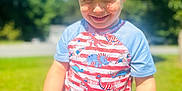 Ezekiel joined the competition — help win amazing prizes! child, boy, smiling, blonde_hair, tshirt, dinosaur_print, shorts, outdoor, sunny, grass, trees, playful, portrait, happy, young, person, summer, daylight, fun, casual_clothing