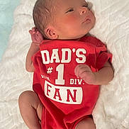 Liam is registered to the contest to win money with this photo: baby, newborn, infant, onesie, red_clothing, blanket, sleeping, cute, feet, hand, face, skin, lying_down, cozy, soft, bed, child, portrait, peaceful, indoors