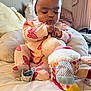 Nova is registered to the contest to win money with this photo: baby, child, infant, toy, plush_toy, bed, pillow, blanket, headband, onesie, pink, butterfly, indoor, cute, focused, sitting, soft, cozy, person, playful