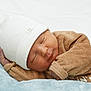 newborn, baby, sleeping, hat, white_hat, brown_outfit, soft_texture, blanket, blue_blanket, infant, peaceful, cute, portrait, child, resting, closeup, indoors, cozy, human, headwear