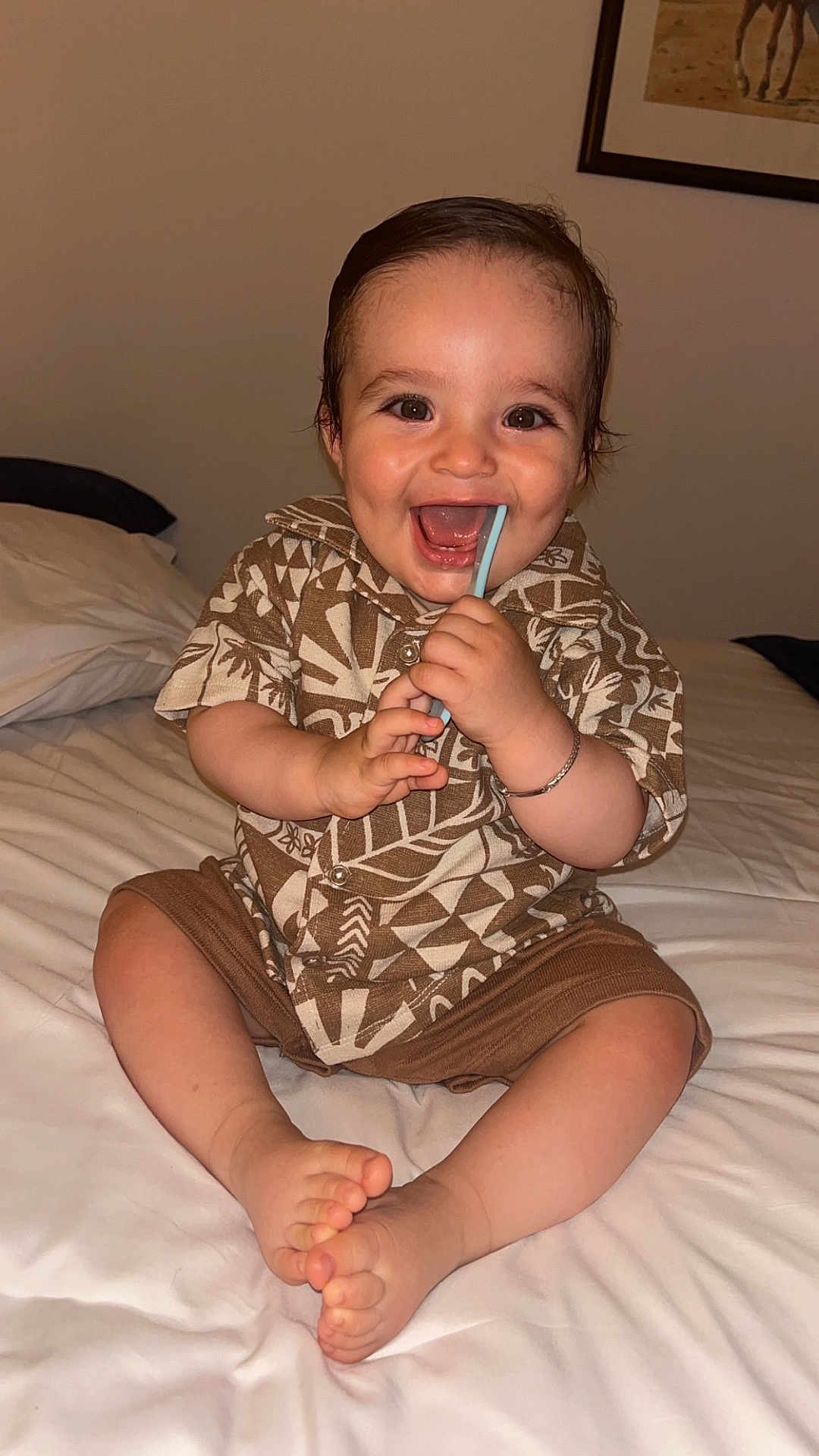 Sinaï participe au concours pour gagner de l'argent avec cette photo : baby, child, smiling, happy, sitting, bed, clothing, shorts, shirt, patterned, indoors, chewing, straw, bracelet, feet, toes, portrait, cute, person, home