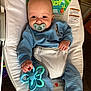 Braxton is registered to the contest to win money with this photo: baby, infant, pacifier, teether, toy, bouncer, baby_bouncer, blue_clothing, onesie, smile, sitting, seat, safety_label, hand, feet, indoors, cute, portrait, nursery, plush