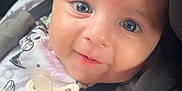 Mia a rejoint le concours — aidez-le/la à gagner de superbes lots ! baby, blanket, blue_eyes, car_seat, child, closeup, clothing, cute, face, hand, happy, indoors, infant, pacifier, person, pink_bow, portrait, seatbelt, smiling, young
