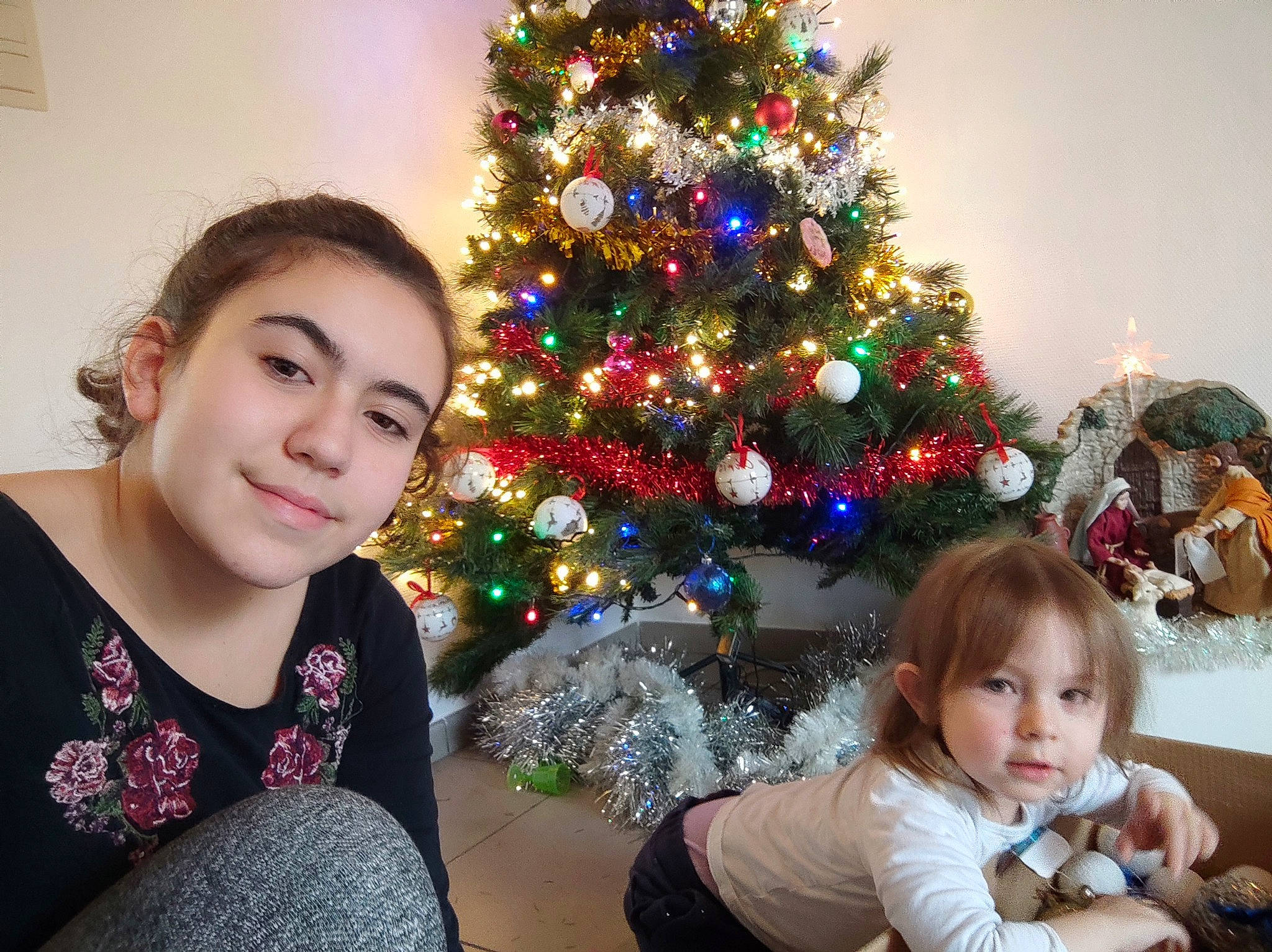 Célya a rejoint le concours — aidez-le/la à gagner de superbes lots ! christmas, christmas_decoration, christmas_eve, christmas_lights, christmas_ornament, christmas_tree, conifer, event, evergreen, holiday, holiday_ornament, human, interior_design, jewellery, joy, ornament, person, pine_family, sitting, toy