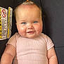 baby, blanket, blue_eyes, car_seat, child, cute, furniture, hand, happy, head, indoor, infant, person, pink_clothing, portrait, seat, skin, smiling, topknot, wood_floor