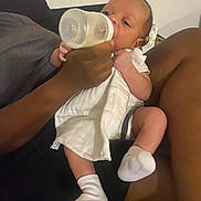 Bacari joined the competition — help win amazing prizes! arm, baby, bottle, care, closeup, comfort, couch, feeding, hand, indoor, infant, leg, nurturing, parent, person, resting, skin, white_clothing, white_socks, young_child