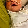 baby, infant, face, blanket, nasal_tube, medical_tape, sleeping, close_up, person, child, swaddled, healthcare, resting, soft_fabric, indoor, skin, cheek, mouth, nose, comfort