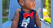 Nova joined the competition — help win amazing prizes! baby, child, outdoor, sunlight, blue_clothing, minnie_mouse, red_bow, earrings, lounge_chair, grass, greenery, skin, portrait, sitting, pensive, drool, cute, summer, infant, person