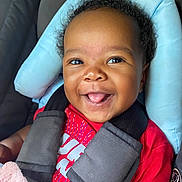 Nylah joined the competition — help win amazing prizes! baby, child, car_seat, smile, tongue_out, red_shirt, seatbelt, black_hair, happy, cute, infant, portrait, closeup, indoors, baby_clothing, car_interior, seat_padding, secure, young_child, person