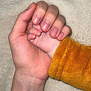 Jihane a rejoint le concours — aidez-le/la à gagner de superbes lots ! adult_hand, baby_hand, holding, close_up, skin, fingers, nails, orange_sleeve, fabric, texture, blanket, soft, tenderness, connection, human, touch, care, comfort, warmth, skin_tone