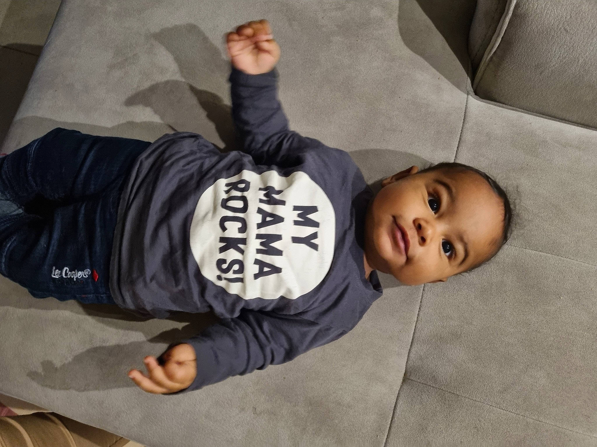 Owen a rejoint le concours — aidez-le/la à gagner de superbes lots ! baby, child, comfort, finger, floor, flooring, fun, gesture, grey, headgear, linens, person, room, sitting, sleeve, smile, snapshot, t_shirt, textile, toddler