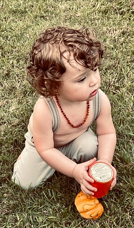 Jasper is registered to the contest to win money with this photo: baby, baby_toddler_clothing, cheek, child, drink, drinking, drinkware, finger, fun, grass, hand, happy, nail, people_in_nature, person, play, sitting, soil, thumb, toddler