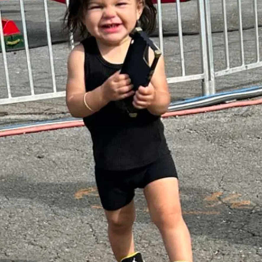 Zuri is registered to the contest to win money with this photo: child, city, clothing, face, female, fence, footwear, girl, gun, happy, head, outdoorplayarea, outdoors, person, photography, playarea, portrait, shoe, shorts, sneaker