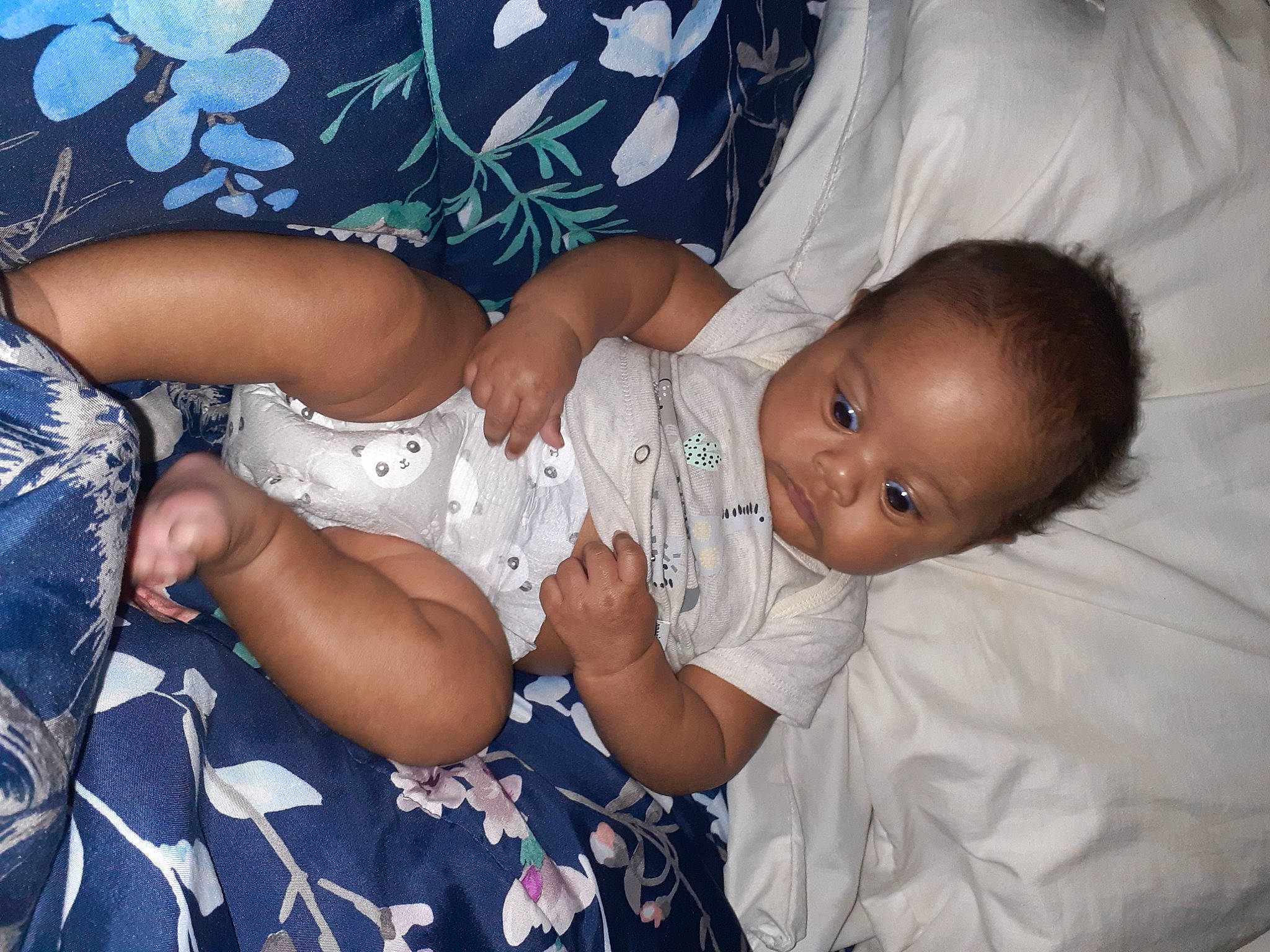 Jesiah is registered to the contest to win money with this photo: arm, baby, baby_toddler_clothing, blue, cheek, comfort, dress, elbow, eye, finger, fun, gesture, happy, human_body, interaction, people, person, skin, smile, toddler