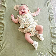 Bishop joined the competition — help win amazing prizes! baby, infant, smiling, blanket, knitted_blanket, ruffles, floral_outfit, headband, white_shoes, socks, lying_down, cute, happy, tongue_out, soft_lighting, indoors, person, child, adorable, portrait