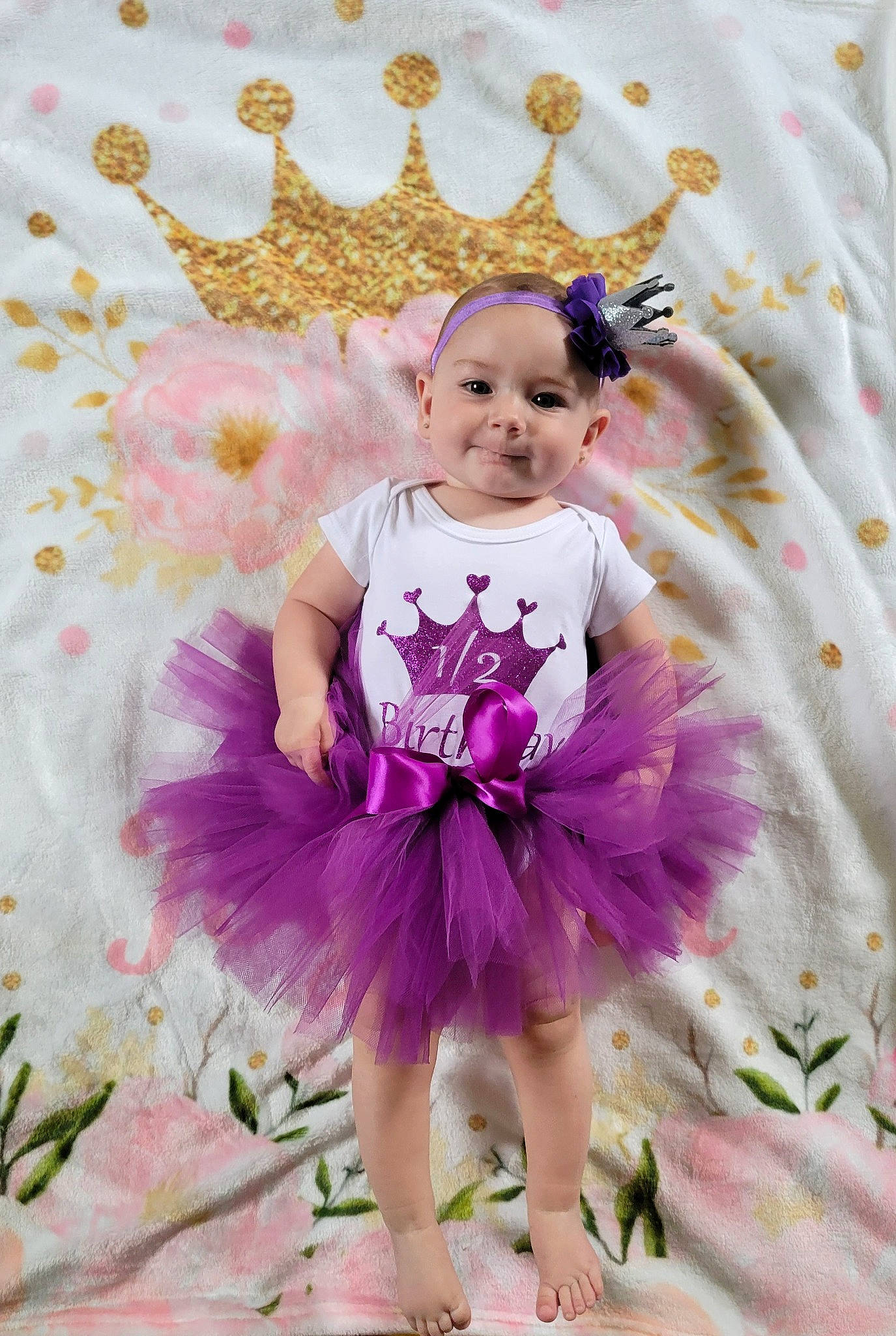Joyann is registered to the contest to win money with this photo: baby_toddler_clothing, day_dress, dress, embellishment, face, fashion_design, formal_wear, fun, happy, headpiece, joy, magenta, mythical_creature, pattern, person, petal, pink, plant, purple, ruffle