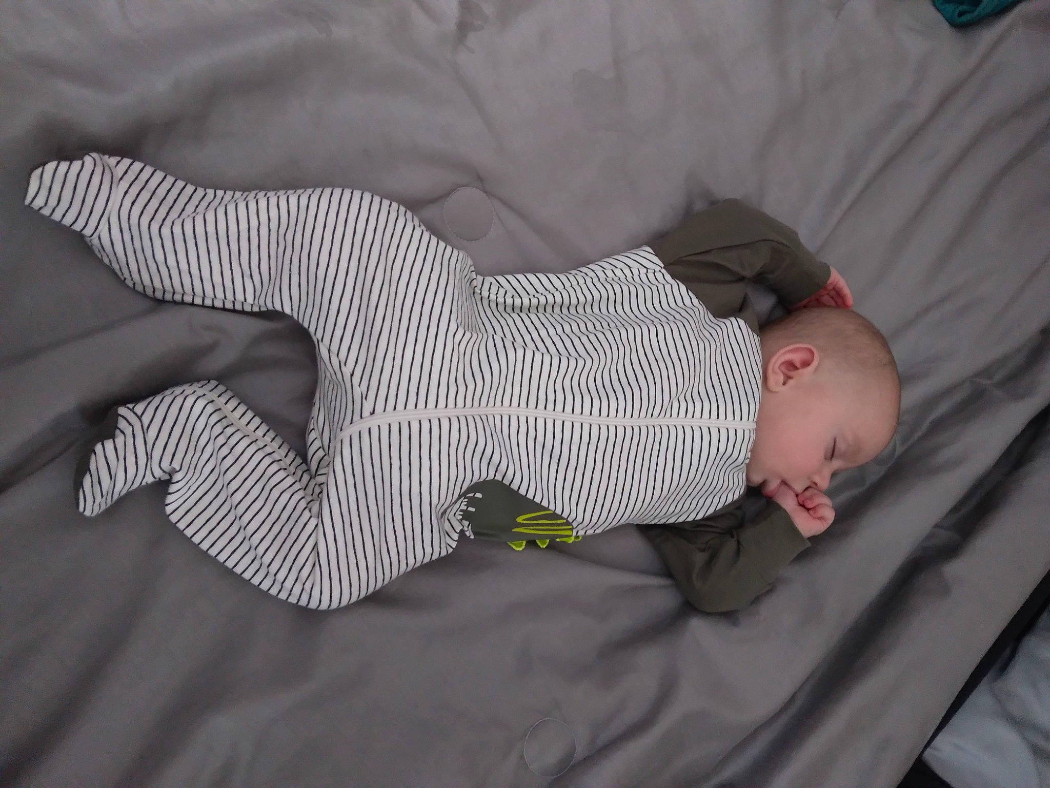 Aidan is registered to the contest to win money with this photo: baby, baby_products, baby_toddler_clothing, child, comfort, elbow, foot, gesture, grey, hand, human_body, human_leg, knee, linens, nap, pattern, person, sleep, sleeve, sock