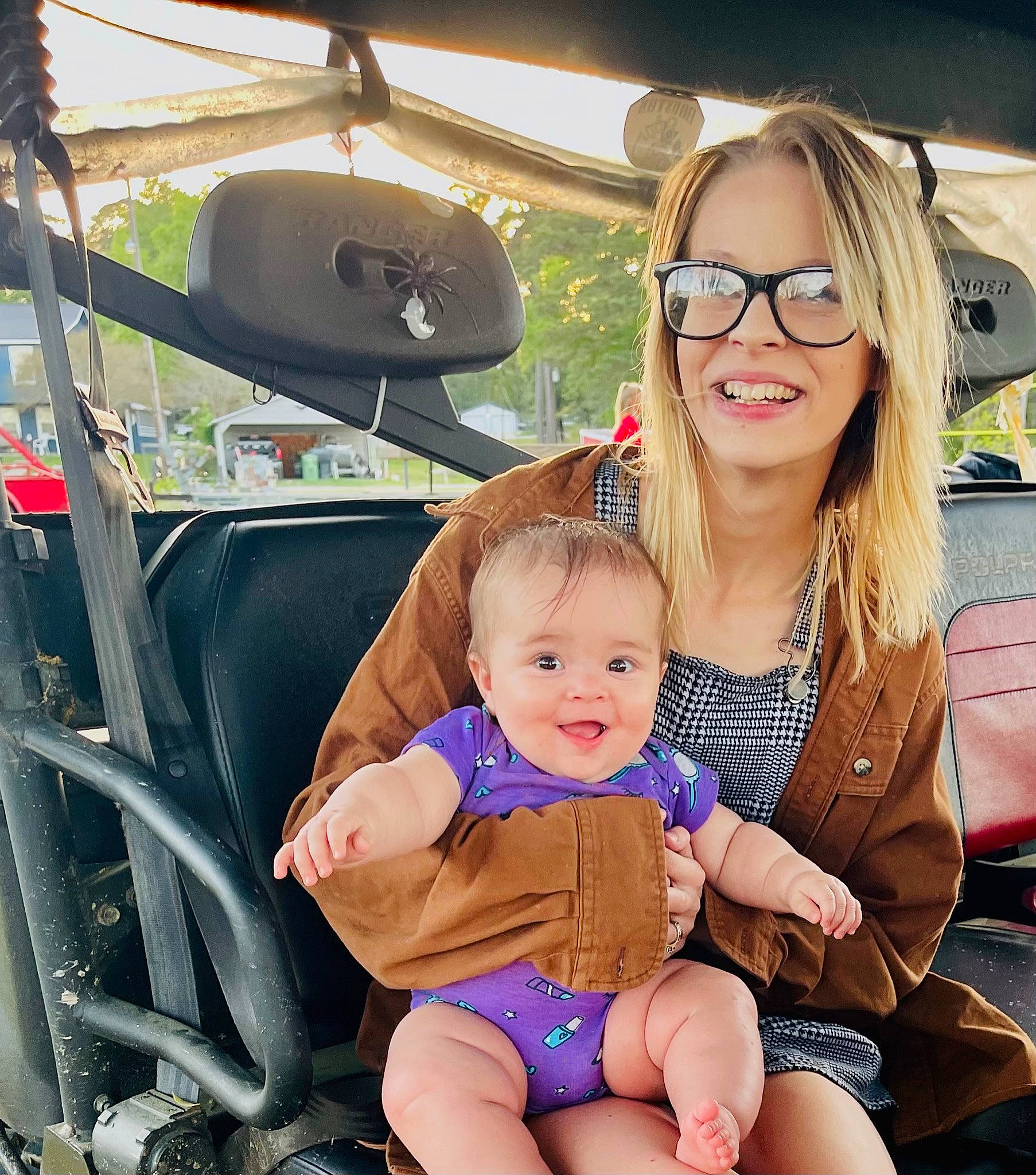 Mari is registered to the contest to win money with this photo: auto_part, automotive_design, automotive_exterior, baby, baby_toddler_clothing, child, event, eyewear, fun, glasses, happy, joy, lap, leisure, motor_vehicle, person, skin, smile, thigh, toddler