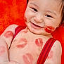 Matthew is registered to the contest to win money with this photo: baby, smiling, face, lipstick, kiss_marks, red_suspender, skin, cheeks, arms, torso, orange_blanket, happy, infant, closeup, portrait, cute, playful, child, lying_down, dimple