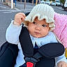 Loudjayn a rejoint le concours — aidez-le/la à gagner de superbes lots ! baby, child, knitted_hat, white_cardigan, car_seat, car_seat_harness, pink_blanket, outdoor, daylight, curious_expression, parked_cars, trees, hand, face, infant, clothing, seatbelt, road, person, cute