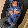baby, blue_clothing, hoodie, mouse_ears, toy, baby_rocker, indoor, floor, curious, smile, child, infant, socks, casual_wear, person, cute, seated, comfortable, bright_eyes, young_child