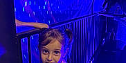 Maja a rejoint le concours — aidez-le/la à gagner de superbes lots ! child, girl, pigtails, overalls, pink_shirt, railing, tunnel, blue_lighting, purple_lighting, lights, curious, indoor, playful, person, young, portrait, handrail, expression, people, dark