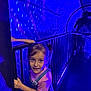 child, girl, pigtails, overalls, pink_shirt, railing, tunnel, blue_lighting, purple_lighting, lights, curious, indoor, playful, person, young, portrait, handrail, expression, people, dark