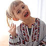 Maja a rejoint le concours — aidez-le/la à gagner de superbes lots ! child, smiling, waving, embroidered_blouse, denim_shorts, indoor, portrait, happy, playful, young_girl, colorful_clothing, casual, seated, person, face, hair_tied, bright, natural_light, cute, gesture