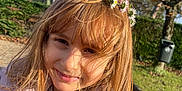 Maja is registered to the contest to win money with this photo: child, girl, flower_crown, outdoor, sunlight, smile, hair, jacket, nature, trees, grass, park, daylight, face, portrait, happy, casual_clothing, young, person, seasonal