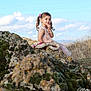 Maja is registered to the contest to win money with this photo: child, girl, pigtails, pink_dress, rock, moss, nature, outdoor, sky, clouds, portrait, bracelet, necklace, grass, hill, smile, young, cute, daylight, landscape