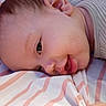 baby, infant, child, portrait, close_up, lying_down, sleepy, awake, face, eye, hair, nose, mouth, blanket, striped_blanket, clothing, indoors, cozy, bedtime, photography