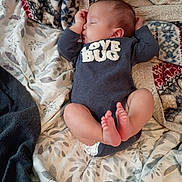 Lucas is registered to the contest to win money with this photo: newborn, baby, sleeping, infant, portrait, indoors, blanket, bed, bedding, onesie, love_bug, face, hands, feet, toes, curled_legs, cozy, lying_down, patterned_fabric, soft_lighting