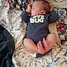 newborn, baby, sleeping, infant, portrait, indoors, blanket, bed, bedding, onesie, love_bug, face, hands, feet, toes, curled_legs, cozy, lying_down, patterned_fabric, soft_lighting