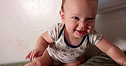 Lucas is registered to the contest to win money with this photo: baby, child, infant, smiling, happy, crawling, sitting, portrait, face, indoors, bedroom, bed, blanket, quilt, clothing, onesie, brown_hair, natural_light, home, cute
