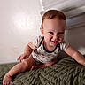 baby, child, infant, smiling, happy, crawling, sitting, portrait, face, indoors, bedroom, bed, blanket, quilt, clothing, onesie, brown_hair, natural_light, home, cute