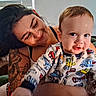 baby, child, adult, parent, portrait, smiling, sitting, indoors, home, window, blinds, couch, tattoo, holding, infant, face, clothing, colorful, vehicles, family