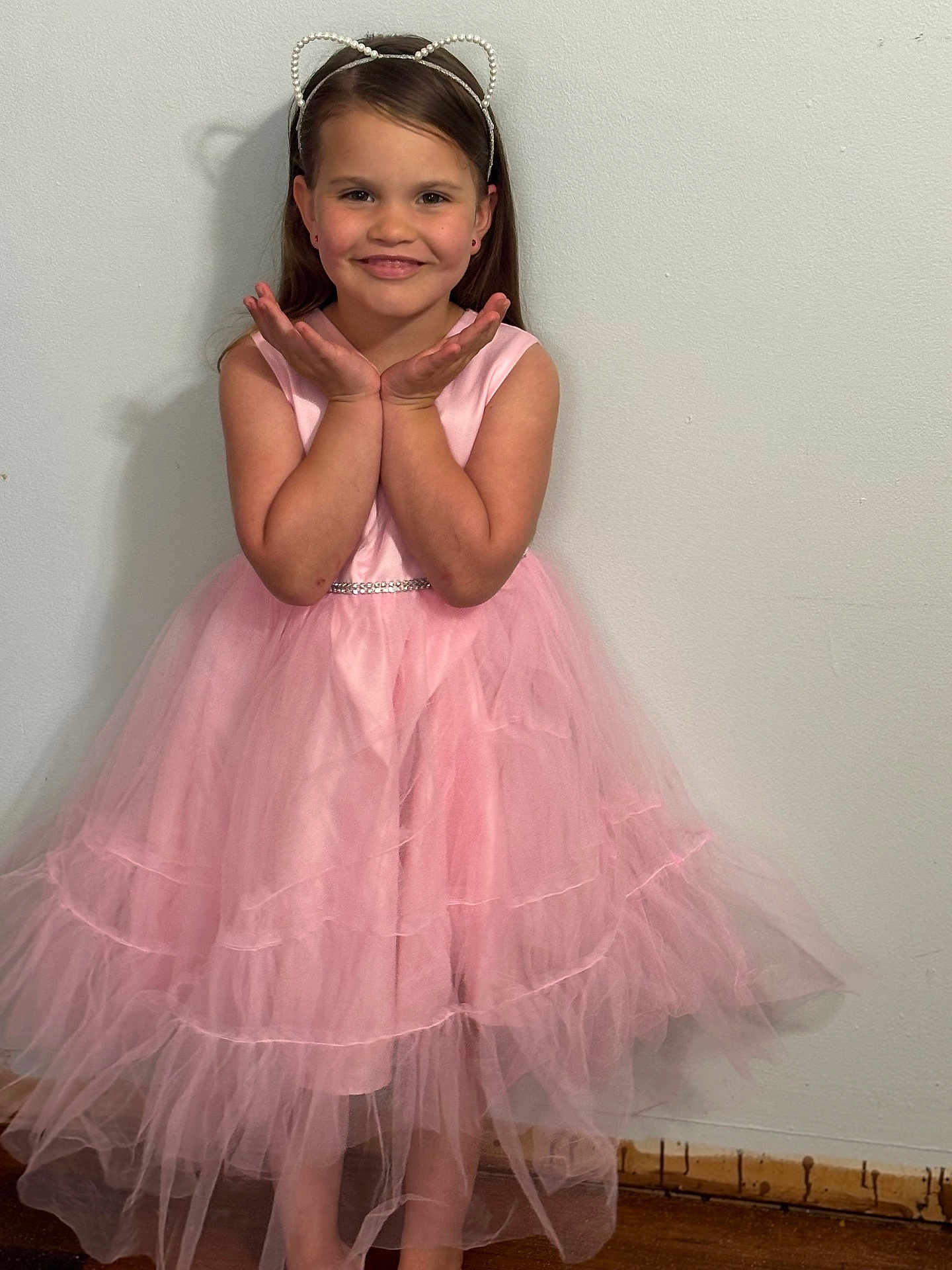 Phoenix is registered to the contest to win money with this photo: child, girl, smiling, pink_dress, tulle, headband, cat_ears, long_hair, standing, pose, happy, wall, floor, indoor, portrait, cute, fashion, accessory, celebration, youth