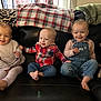 child, toddler, smiling, couch, blanket, indoor, clothing, denim, plaid, barefoot, happy, portrait, person, sitting, holding_hands, family, cute, baby, cozy, home