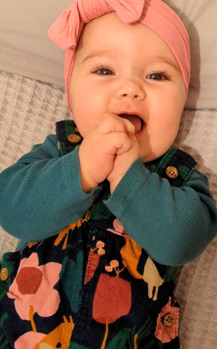 Georgie joined the competition — help win amazing prizes! baby, baby_toddler_clothing, cheek, collar, dress, eye, face, gesture, hand, hat, headwear, iris, lip, mouth, nose, outerwear, person, pink, skin, sleeve
